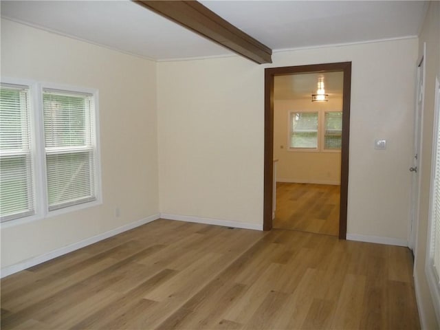 spare room with hardwood / wood-style floors and beam ceiling