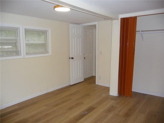 unfurnished bedroom with light wood-type flooring and a closet