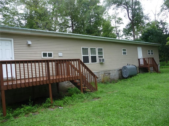 rear view of house featuring a lawn and a deck