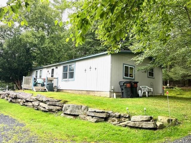 rear view of property featuring a deck and a yard