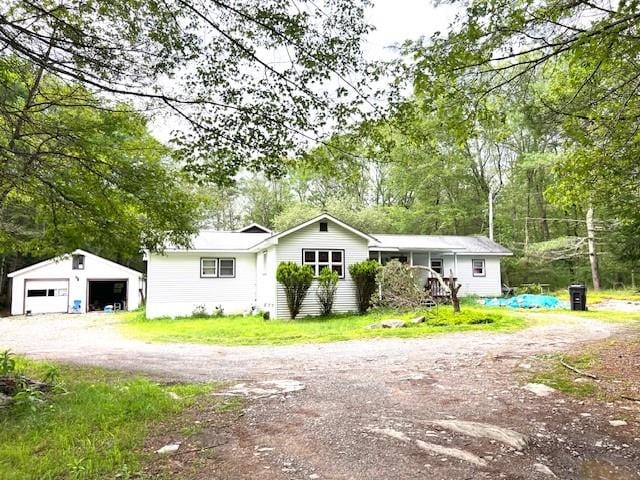 ranch-style home featuring a garage and an outbuilding