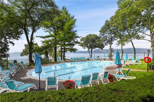 view of pool featuring a yard, a patio, and a water view