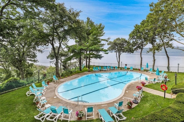 view of pool featuring a patio area, a yard, and a water view