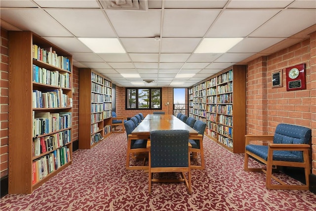 carpeted dining space with a drop ceiling and built in features