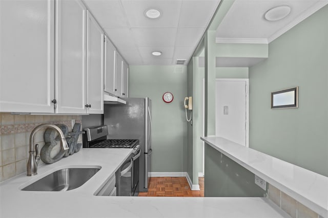 kitchen with decorative backsplash, parquet flooring, sink, white cabinetry, and stainless steel range with gas stovetop