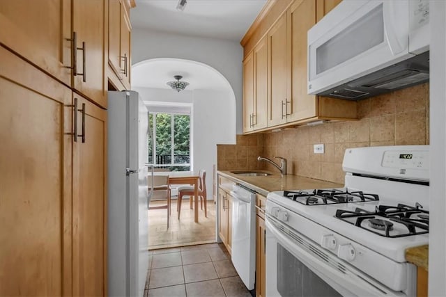 2727 Palisade Ave Unit 7B, Bronx, NY 10463 - kitchen with white appliances, arched walkways, decorative backsplash, light tile patterned flooring, and light countertops