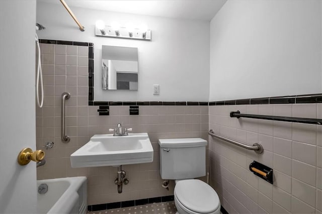 bathroom with toilet, tile walls, and sink