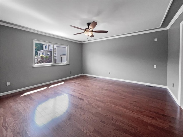 spare room featuring crown molding, ceiling fan, and dark wood-type flooring