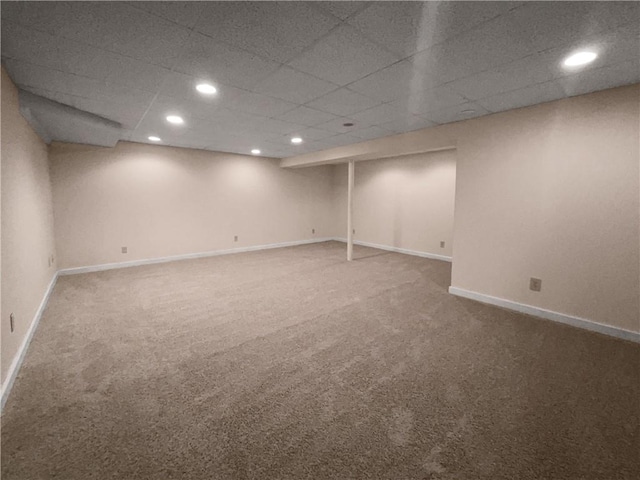 basement featuring a drop ceiling and carpet floors