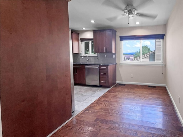 kitchen with sink, stainless steel dishwasher, decorative backsplash, ceiling fan, and light hardwood / wood-style floors