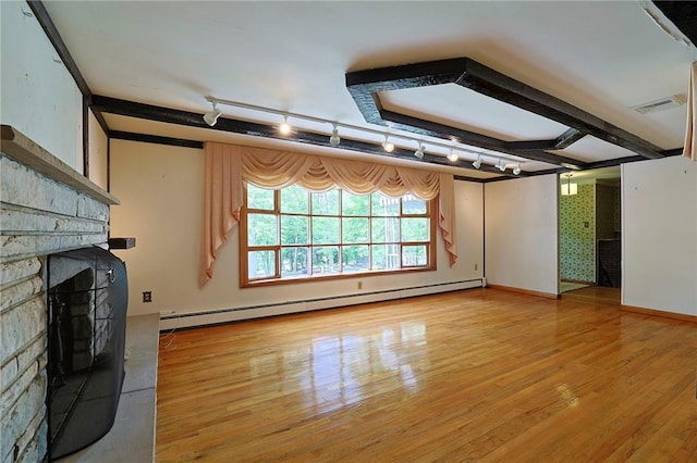 unfurnished living room featuring a stone fireplace, hardwood / wood-style floors, and a baseboard heating unit