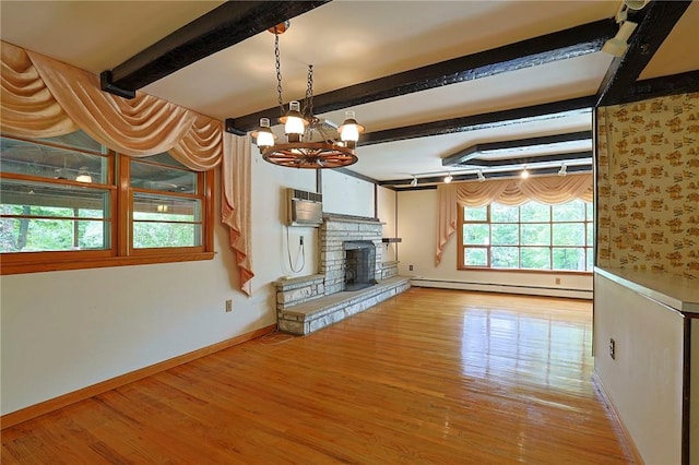 unfurnished living room with a baseboard radiator, an inviting chandelier, light hardwood / wood-style flooring, beamed ceiling, and a fireplace