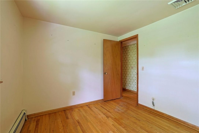 spare room featuring light hardwood / wood-style floors and baseboard heating