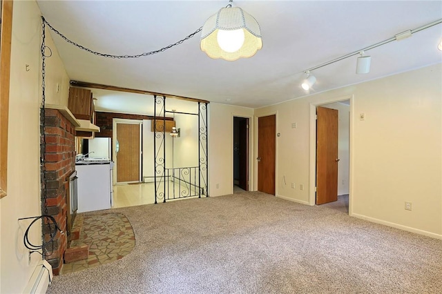 unfurnished living room featuring baseboard heating, light carpet, and track lighting