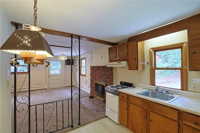 kitchen featuring pendant lighting, a healthy amount of sunlight, sink, and gas range gas stove