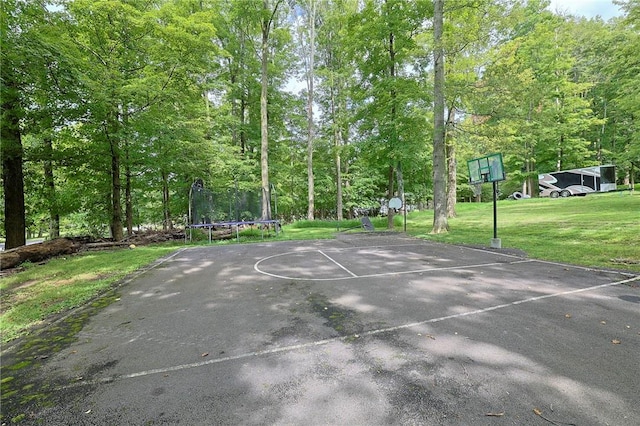 view of basketball court with a trampoline and a yard