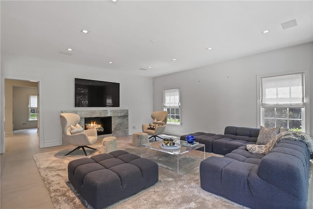 tiled living area with recessed lighting, a fireplace, and baseboards