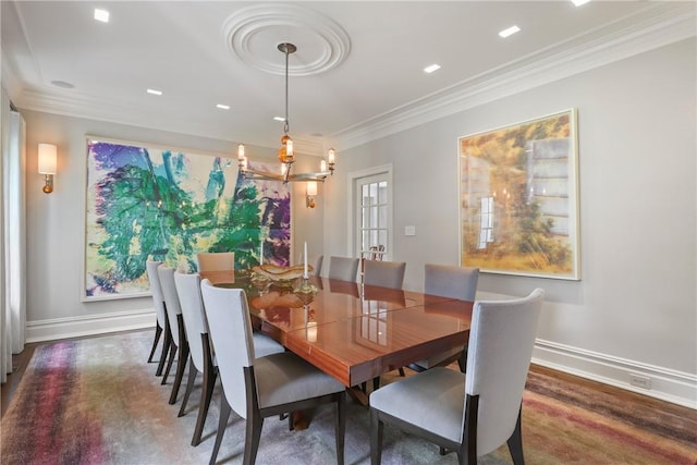 dining space with crown molding, baseboards, and wood finished floors