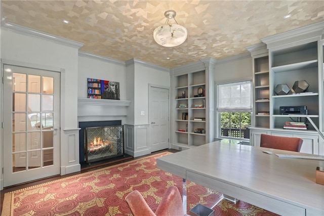 office with built in features, a warm lit fireplace, crown molding, and wood finished floors