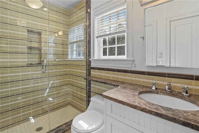 full bathroom with tile walls, toilet, a shower stall, and vanity