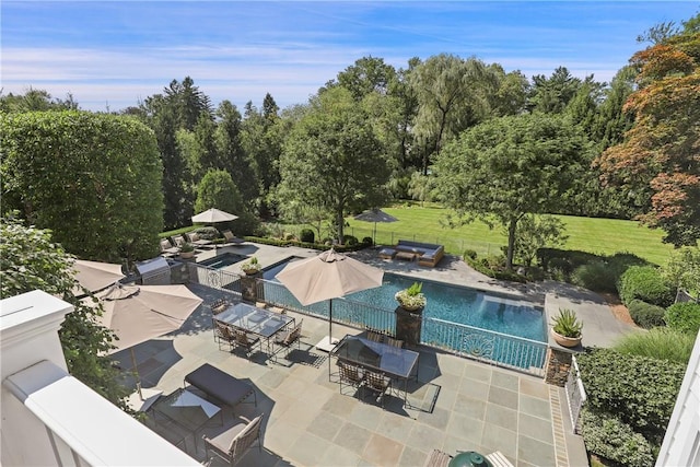 outdoor pool featuring outdoor dining space, a patio, and a yard