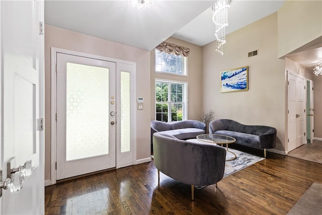 living room with a notable chandelier and dark wood-type flooring