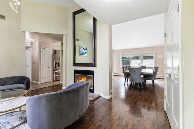 living room featuring dark hardwood / wood-style floors, baseboard heating, and lofted ceiling