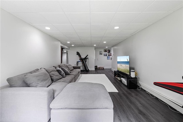 living room with a drop ceiling and dark wood-type flooring