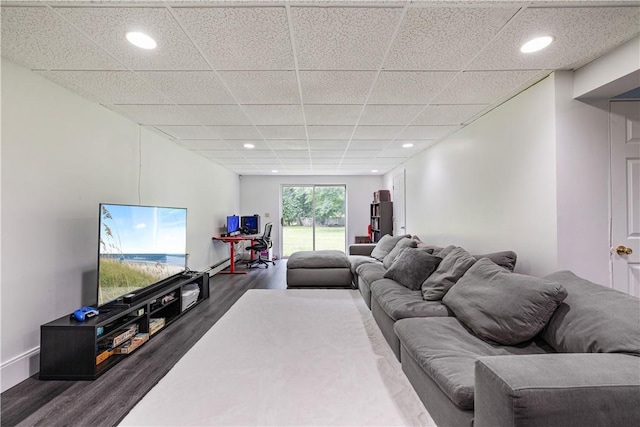 living room with a paneled ceiling and dark hardwood / wood-style flooring