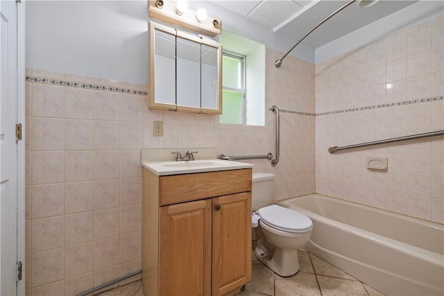 full bathroom featuring vanity, tile patterned floors, tiled shower / bath combo, toilet, and tile walls