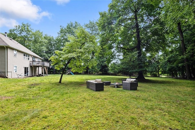 view of yard with an outdoor living space and a wooden deck