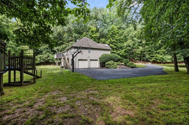 view of side of property featuring a lawn, a garage, and a deck