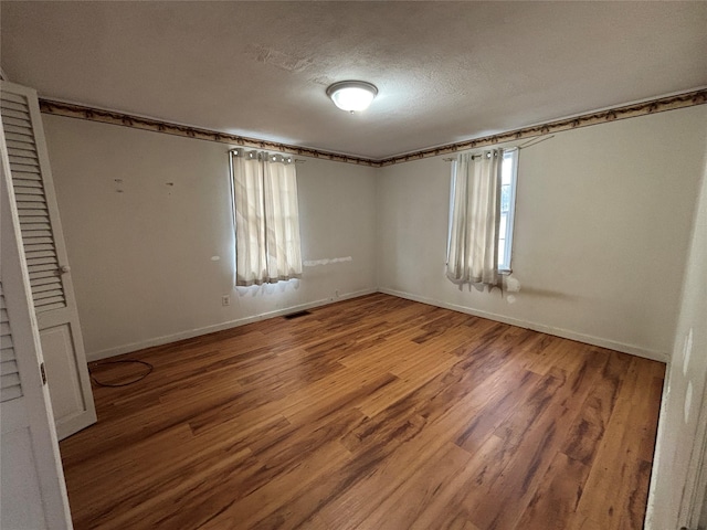 unfurnished bedroom with a textured ceiling and hardwood / wood-style floors