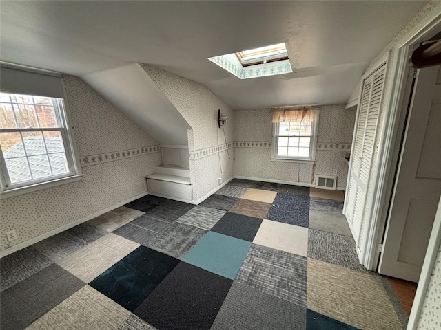 additional living space with lofted ceiling with skylight