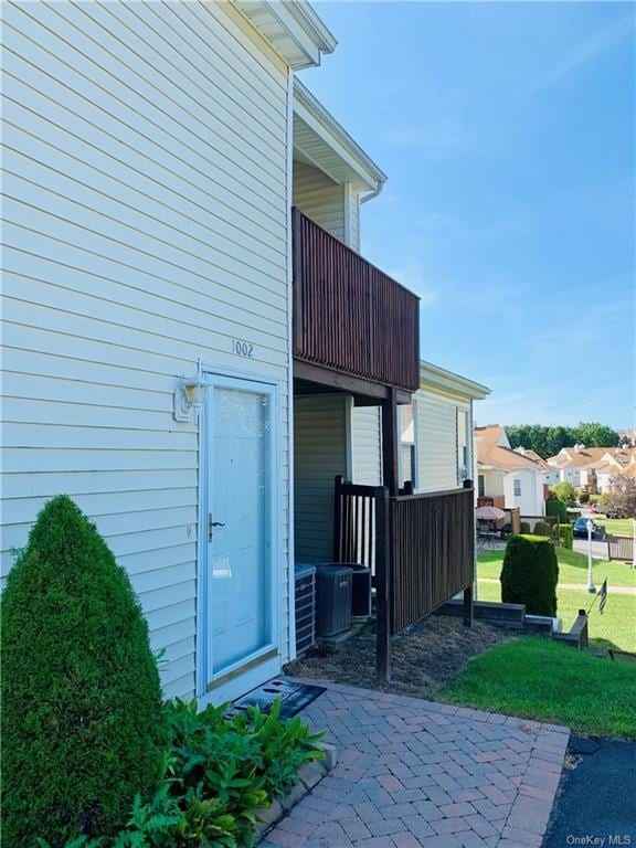 doorway to property featuring a yard, a patio, and central AC