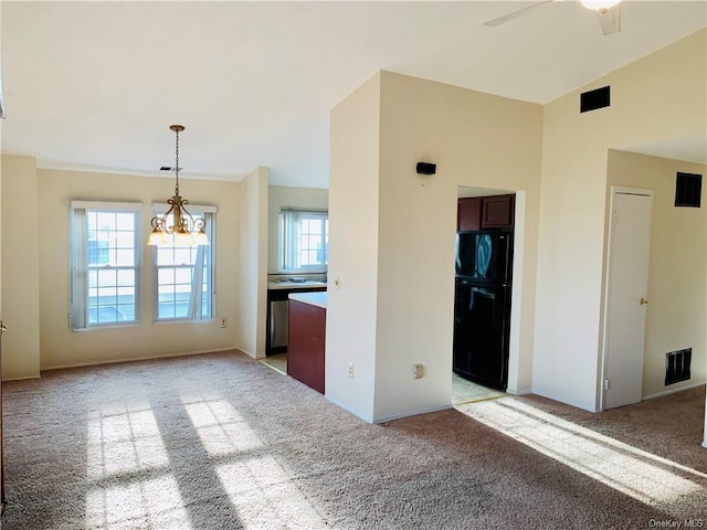 interior space featuring black fridge, ceiling fan with notable chandelier, light colored carpet, pendant lighting, and lofted ceiling