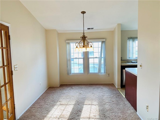 unfurnished dining area with light carpet and an inviting chandelier