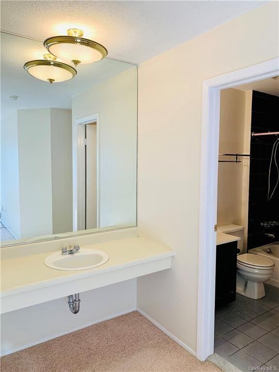 full bathroom with sink, tile patterned flooring, tiled shower / bath combo, toilet, and a textured ceiling