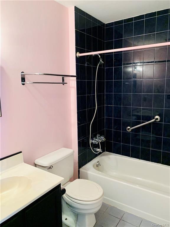 full bathroom with toilet, vanity, tile patterned floors, and tiled shower / bath combo