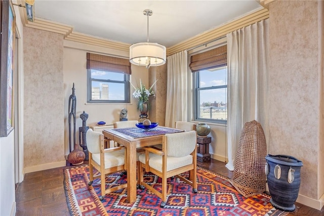 dining room with dark parquet floors, a healthy amount of sunlight, and ornamental molding