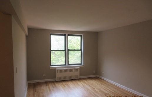 2244 Bronx Park E Unit 6L, Bronx, NY 10467 - unfurnished room with radiator, light wood-style floors, and baseboards