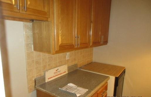 2244 Bronx Park E Unit 6L, Bronx, NY 10467 - kitchen featuring tasteful backsplash and brown cabinets