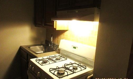2244 Bronx Park E Unit 6L, Bronx, NY 10467 - kitchen featuring white range with gas stovetop, decorative backsplash, extractor fan, and a sink