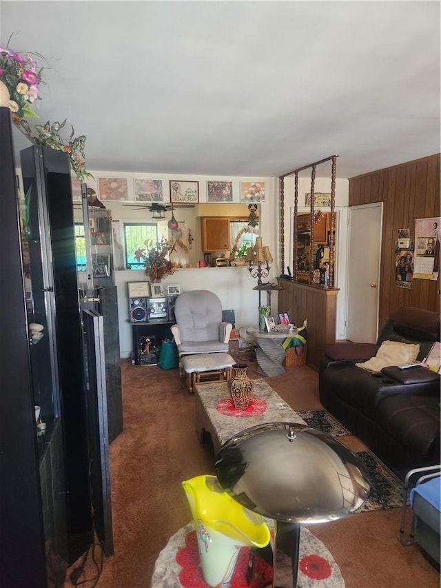 living room featuring dark carpet and wooden walls