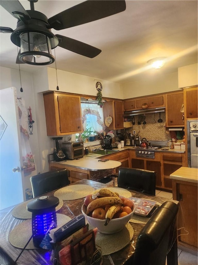 kitchen featuring decorative backsplash, ceiling fan, and appliances with stainless steel finishes