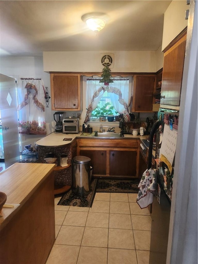 kitchen featuring light tile patterned floors and sink