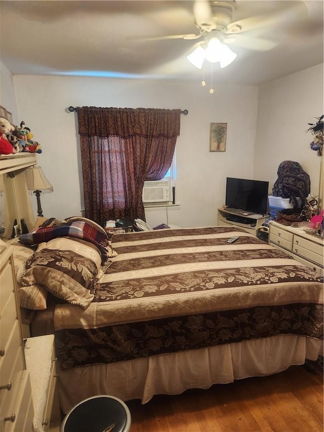 bedroom with wood-type flooring, ceiling fan, and cooling unit