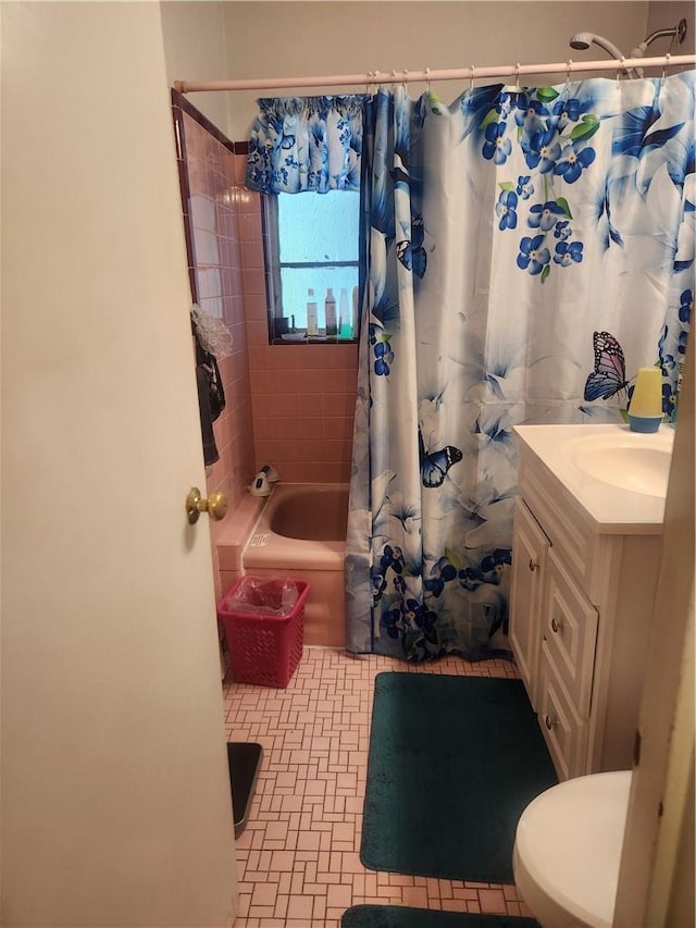 full bathroom with tile patterned floors, shower / bath combo with shower curtain, vanity, and toilet