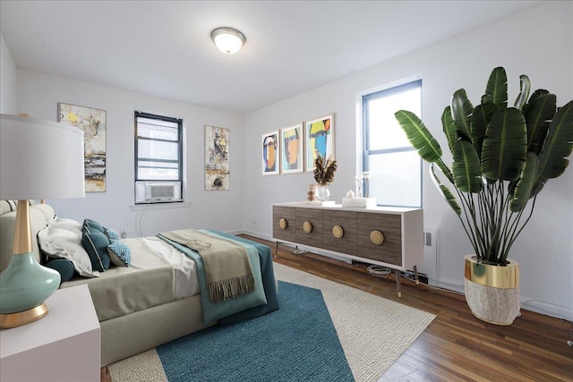 bedroom with cooling unit and dark hardwood / wood-style flooring