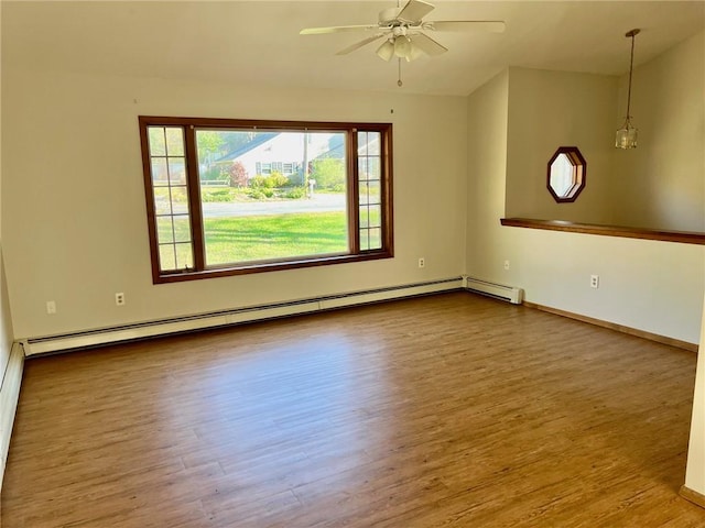 empty room featuring hardwood / wood-style flooring, a baseboard radiator, and ceiling fan